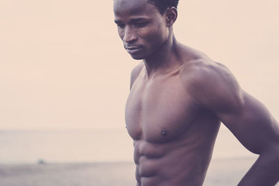 Shirtless muscular man standing at beach