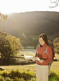 Mature female hiker reading map