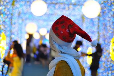 Side view of woman wearing santa hat at night