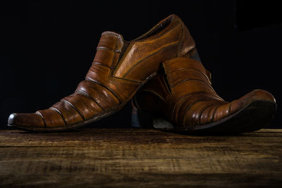 Close-up of shoes on table against black background