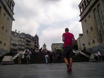 People walking on street amidst buildings in city