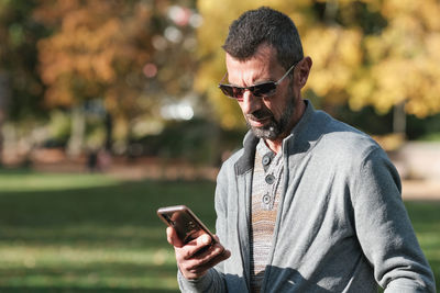 Young man using mobile phone outdoors