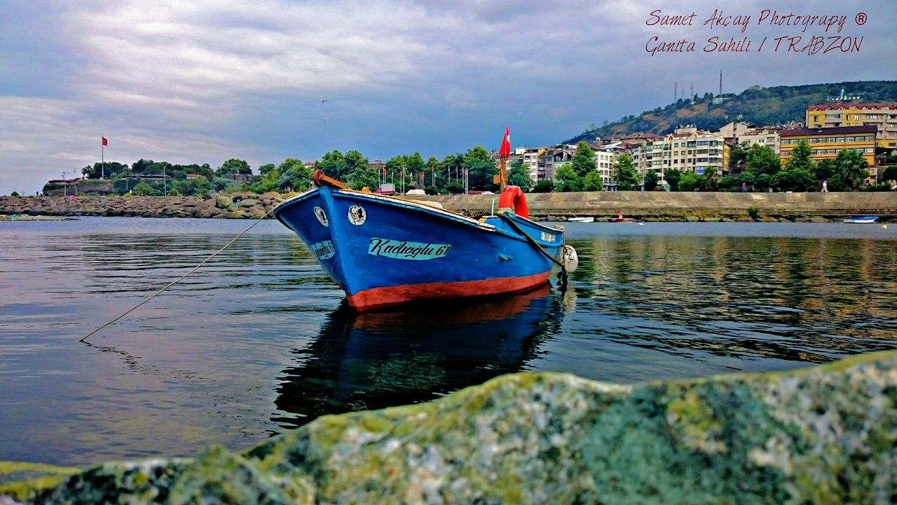 water, sky, architecture, building exterior, built structure, nautical vessel, waterfront, river, cloud - sky, flag, cloud, city, boat, transportation, rippled, sea, outdoors, lake, day, mode of transport