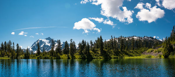 Panoramic view of trees by lake against sky