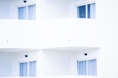 Low angle view of white hotel with balkony 