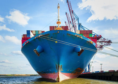 Front of a containership seen from the waterline - center axe view of freight ship being loaded