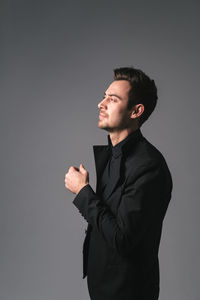 Young man looking away against white background