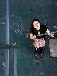 High angle portrait of smiling mid adult woman on swing