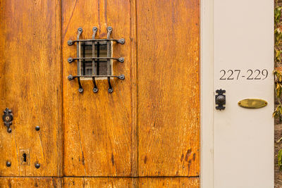 Peephole, doorbell and house numbers at closed, old wooden front door, utrecht, the netherlands