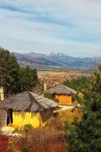 Scenic view of mountains and houses against sky