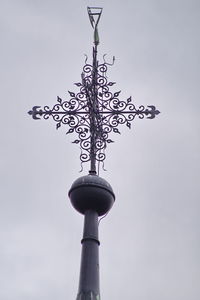 Low angle view of weather vane against clear sky