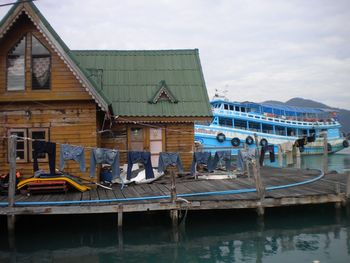 Boats moored on lake against buildings