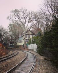 Railroad tracks by trees against sky