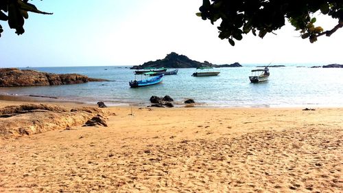 Boats moored on beach against sky