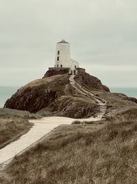 Lighthouse by sea against sky