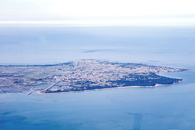 Aerial view of sea and cityscape against sky