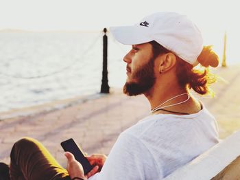 Young man using mobile phone in sea