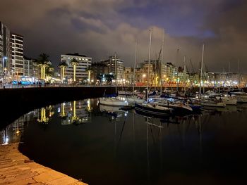 Sailboats moored in harbor at night