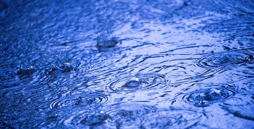 Full frame shot of raindrops on blue water