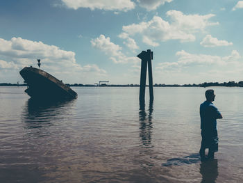 Man standing in elbe river against sky