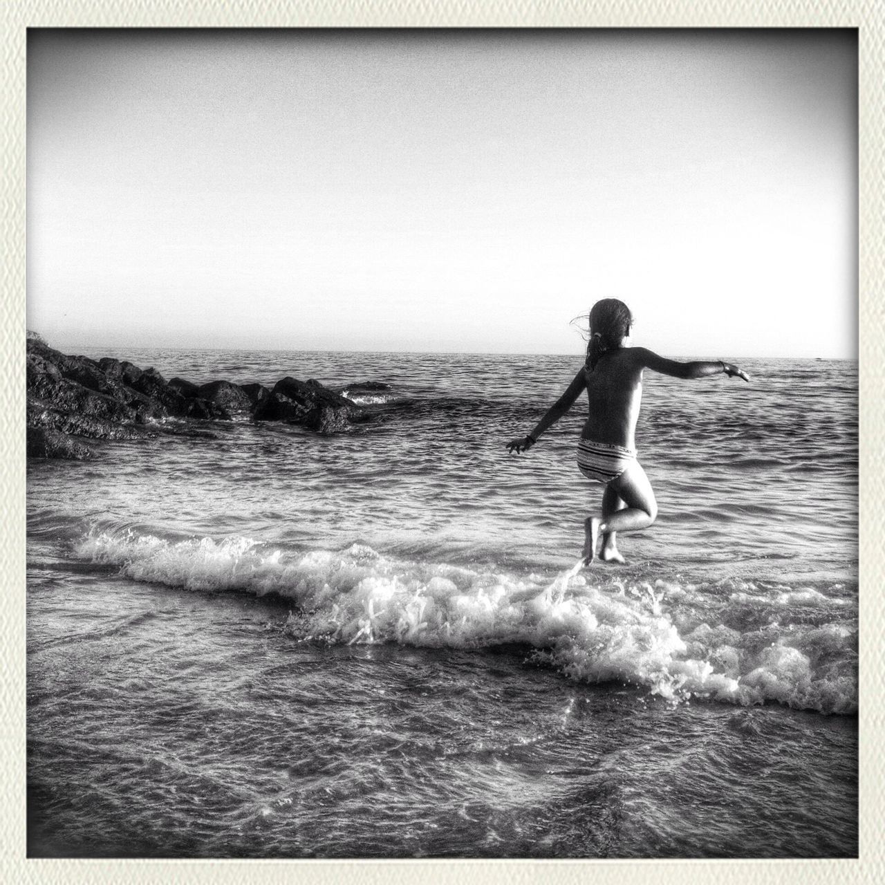 water, sea, waterfront, leisure activity, horizon over water, transfer print, lifestyles, wave, full length, auto post production filter, motion, vacations, surf, splashing, enjoyment, nature, surfboard, clear sky