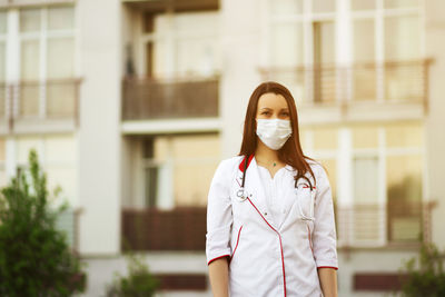 Portrait of doctor wearing mask standing outdoors