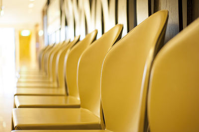 Empty yellow chairs arranged in row