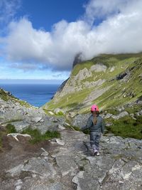 Full length of girl on rocks against sky and mountain 