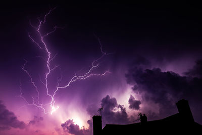 Low angle view of lightning against sky at night