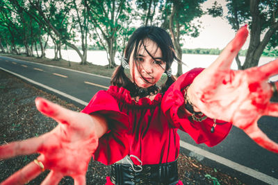 Portrait of woman covered in blood on road