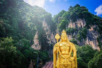 Statue against trees and mountains