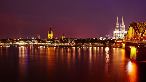 Illuminated hohenzollern bridge over rhine river with reflection at night