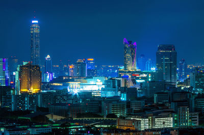 Illuminated buildings in city against sky at night