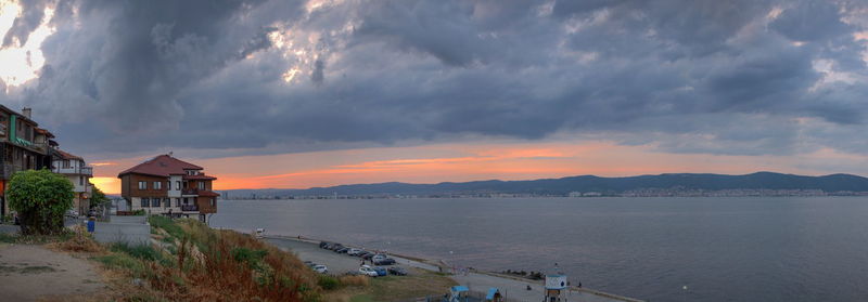 Panoramic view of beach and buildings against sky during sunset
