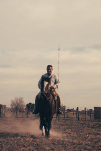 Front view of man riding horse