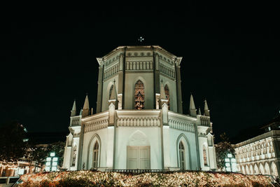 Low angle view of illuminated building against sky at night