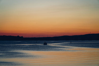 Scenic view of beach against orange sky