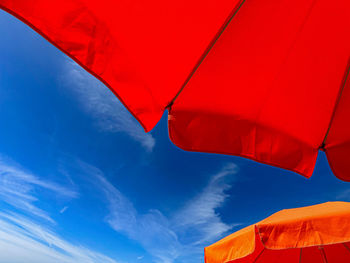 Low angle view of beach umbrellas against a blue sky