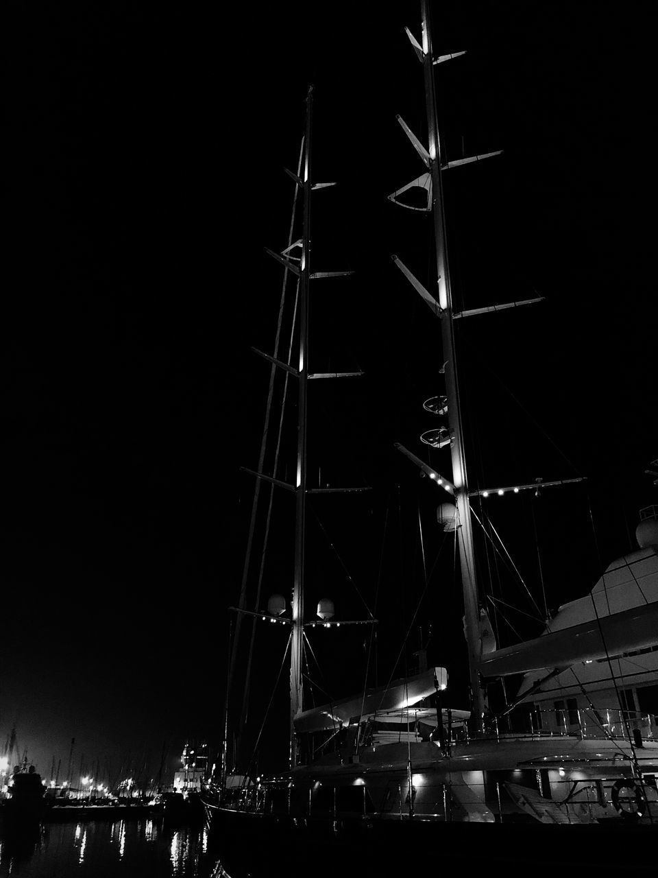 LOW ANGLE VIEW OF ILLUMINATED COMMERCIAL DOCK AT NIGHT