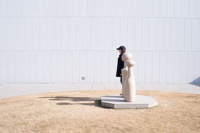 Full length of man standing against wall