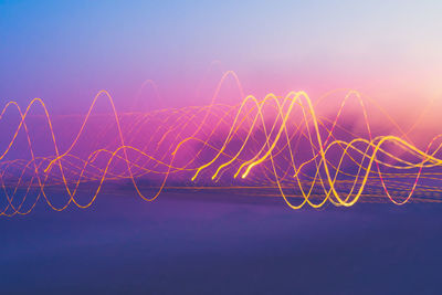 Light trails against sky at dusk