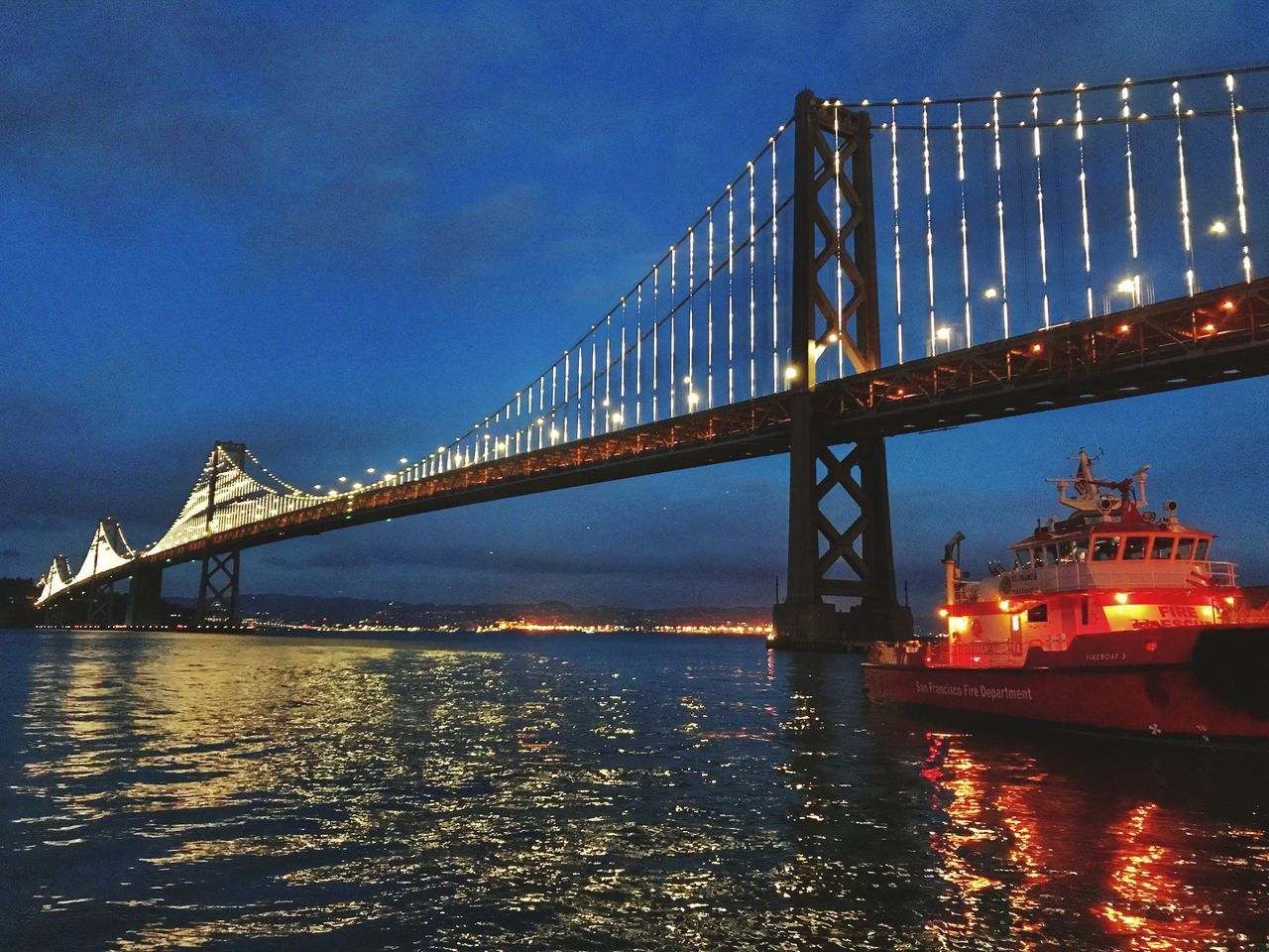 SUSPENSION BRIDGE OVER SEA AGAINST SKY