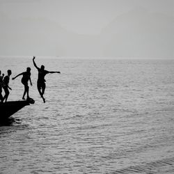 Men in sea against sky