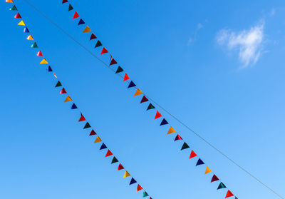 Low angle view of decoration hanging against blue sky