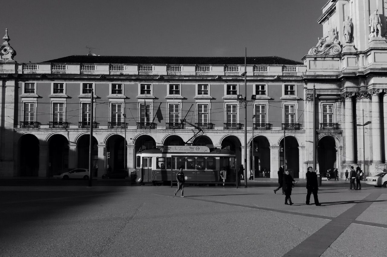 architecture, built structure, building exterior, arch, facade, history, architectural column, city, travel destinations, building, famous place, town square, tourism, column, person, street, travel, large group of people, men