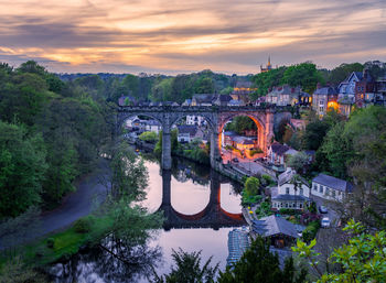 Bridge over river against sky during sunset