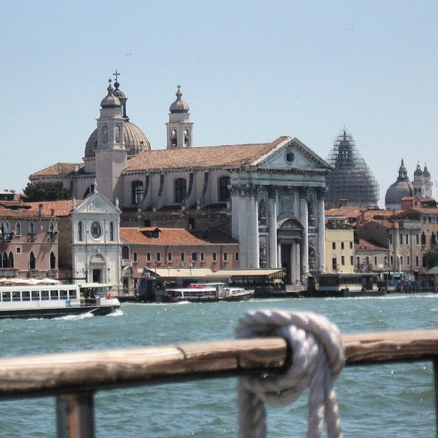 building exterior, water, architecture, built structure, clear sky, river, canal, dome, nautical vessel, railing, place of worship, church, city, waterfront, travel destinations, transportation, religion, spirituality, famous place