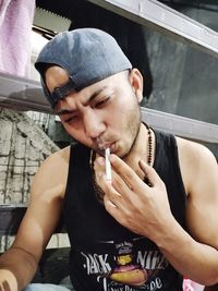 Portrait of young man holding cigarette