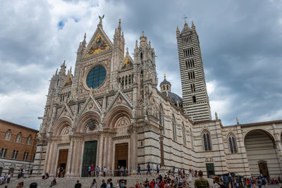 Group of people in front of siena dome, toscana, italy, against sky