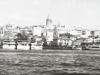 View of cityscape by sea against sky